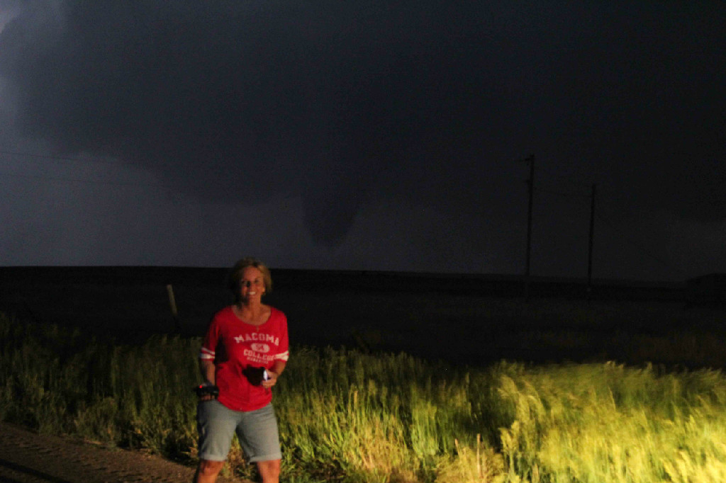 Tour guest taking photo with nighttime tornado